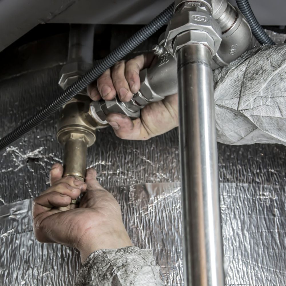 Hands assembling brass pipe fittings