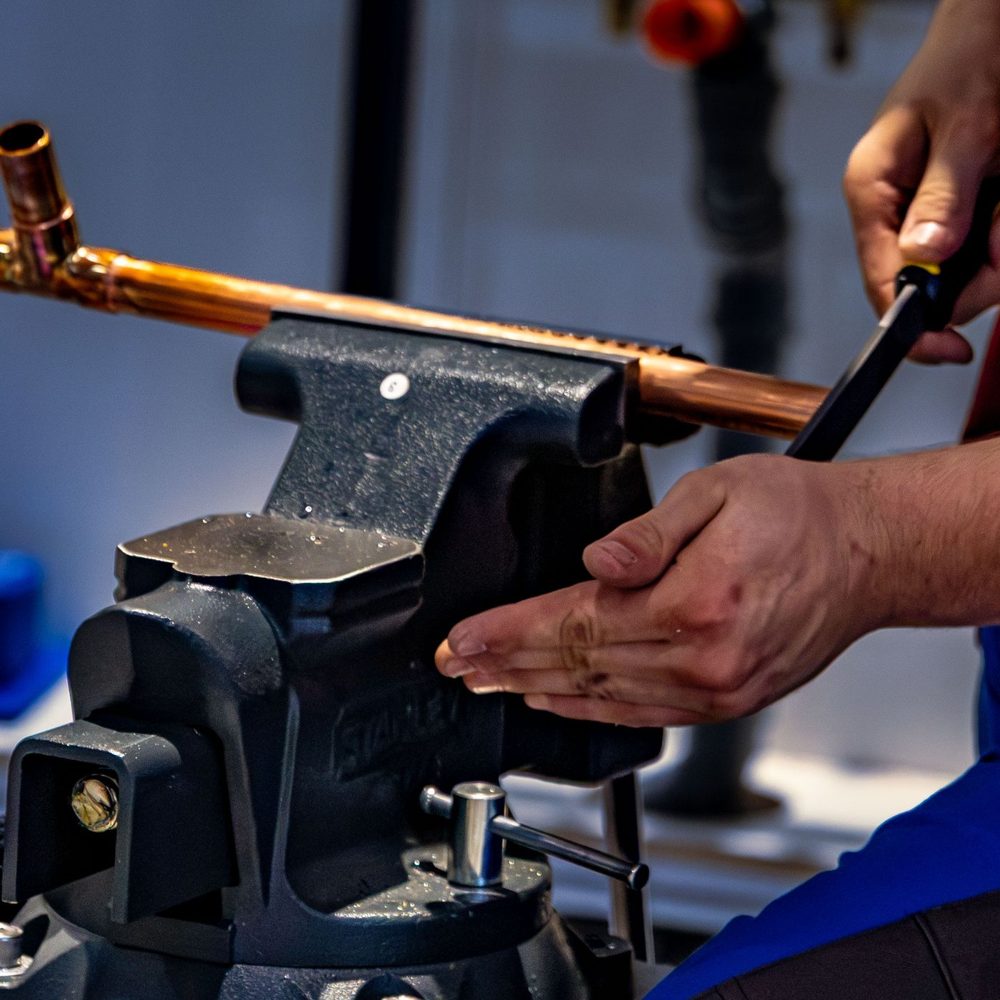 Copper pipe being cut in a vise during a repipe