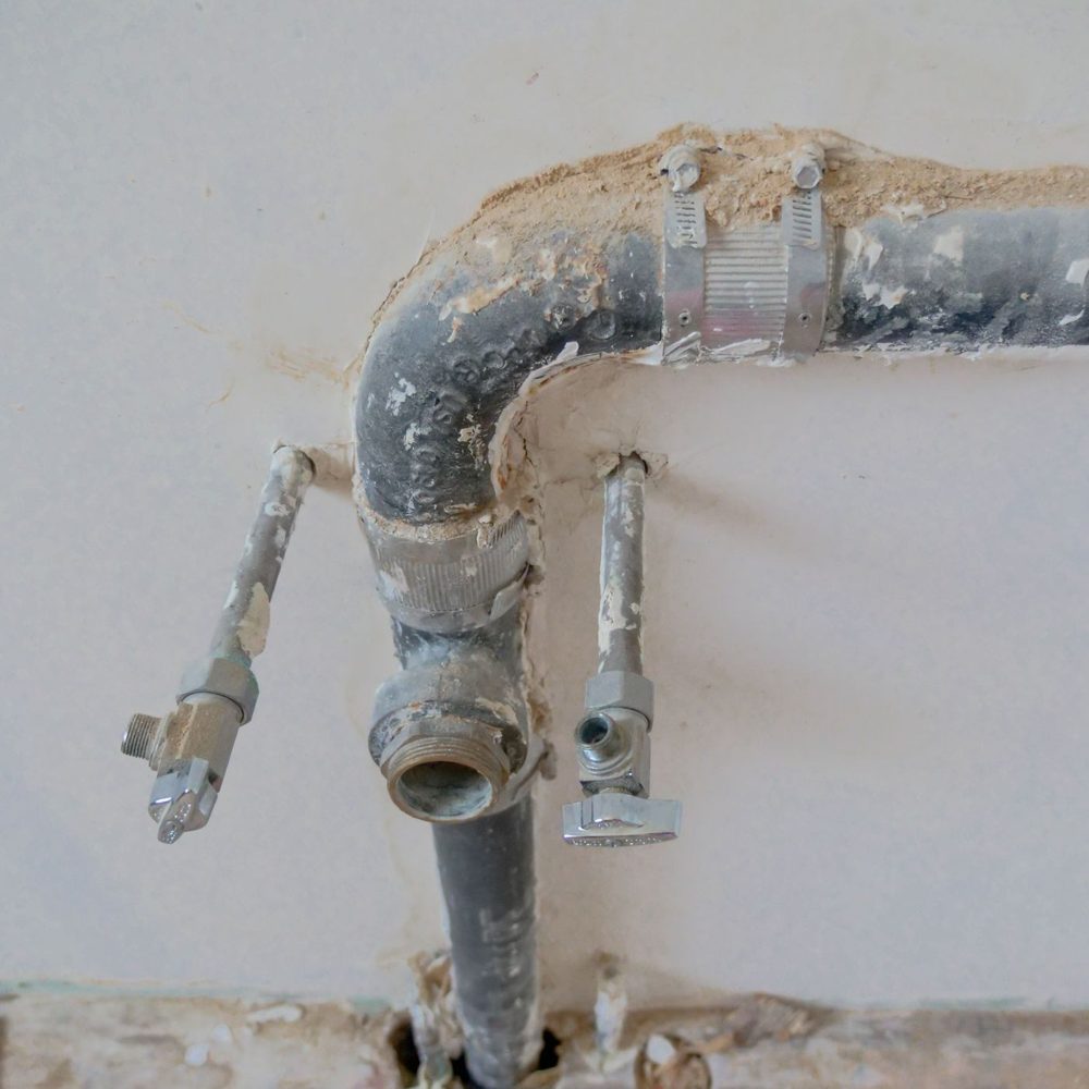 Old galvanized pipe and valves passing through a wall