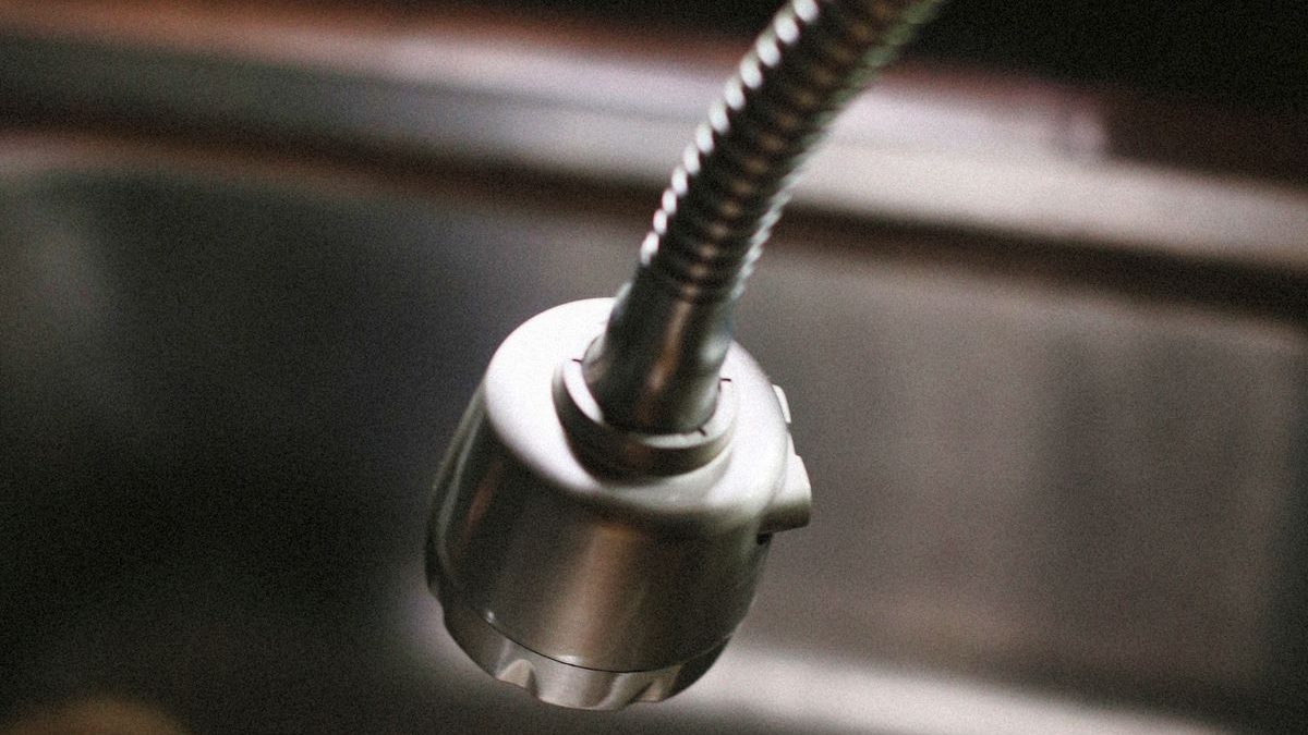 Kitchen faucet running over a sink during a fixture check