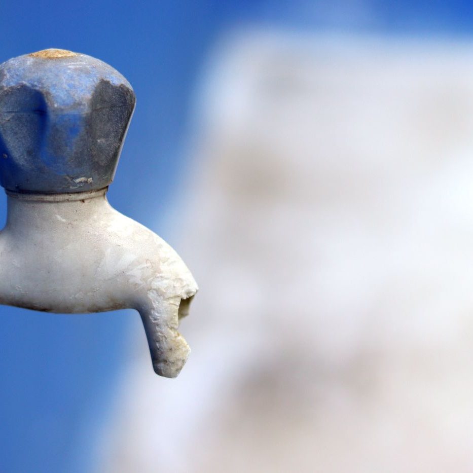Outdoor faucet on a blue wall