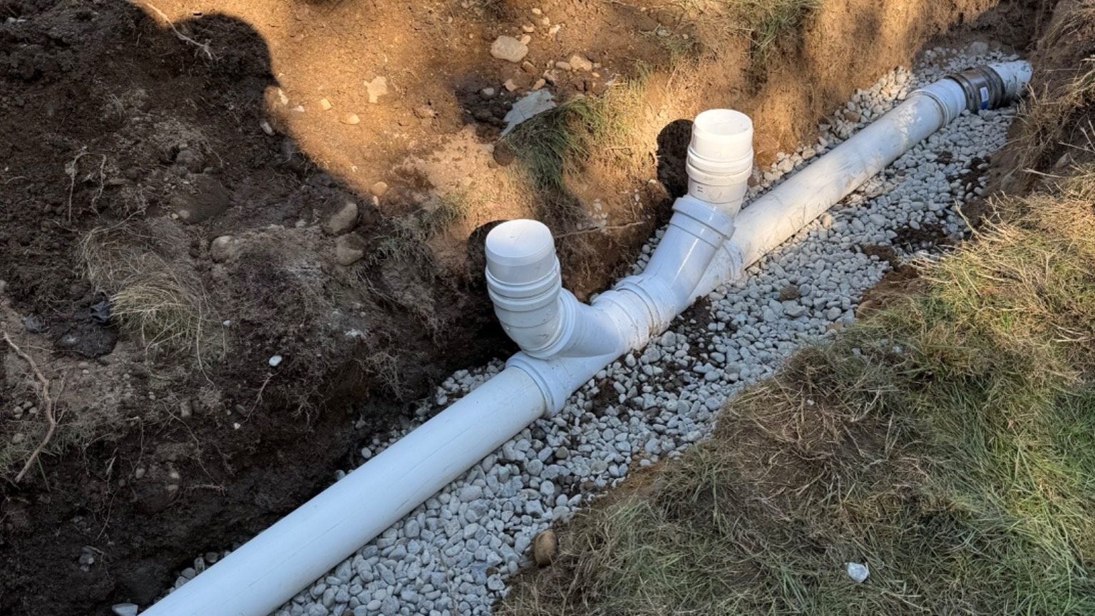 PVC drain and sewer pipe in a gravel trench with cleanout fittings