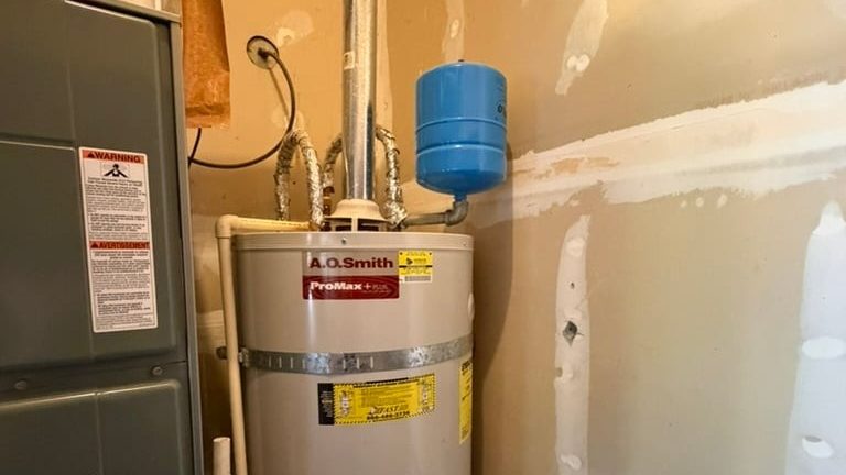 Tank water heater and blue expansion tank on a Rooster's Plumbing job