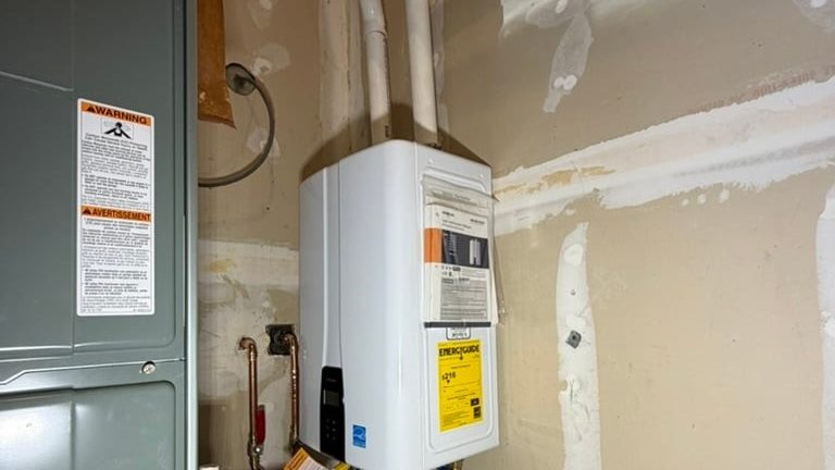 Tankless water heater installed beside a furnace on a Rooster's Plumbing job