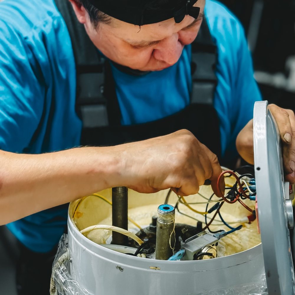 Technician working at the top of a tank water heater